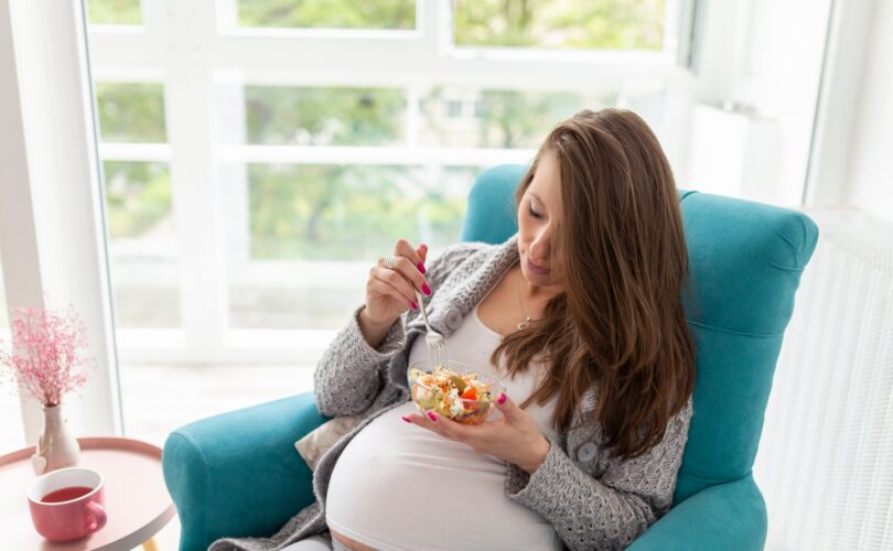 Pregnant woman eating salad