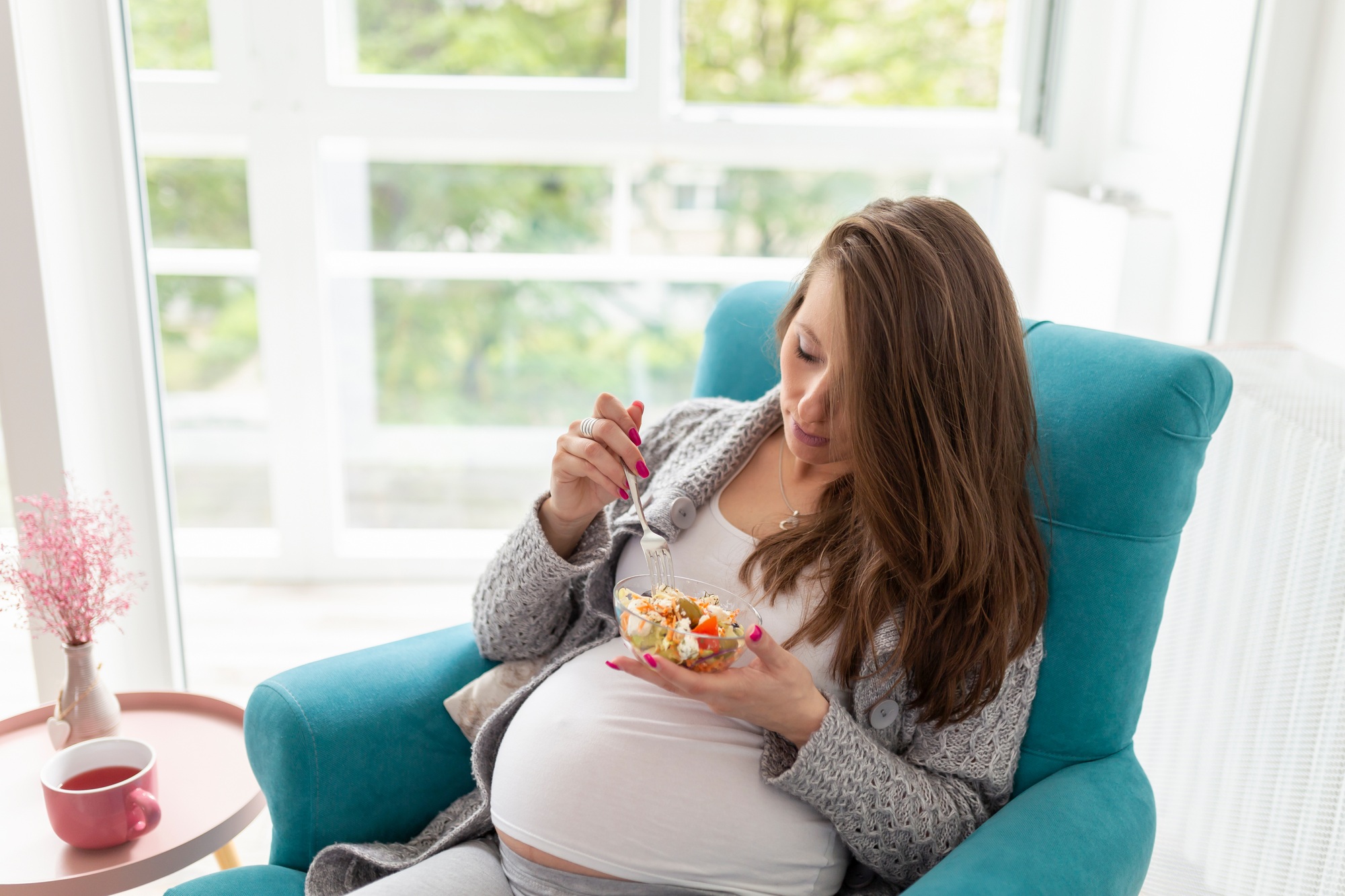 Pregnant woman eating salad