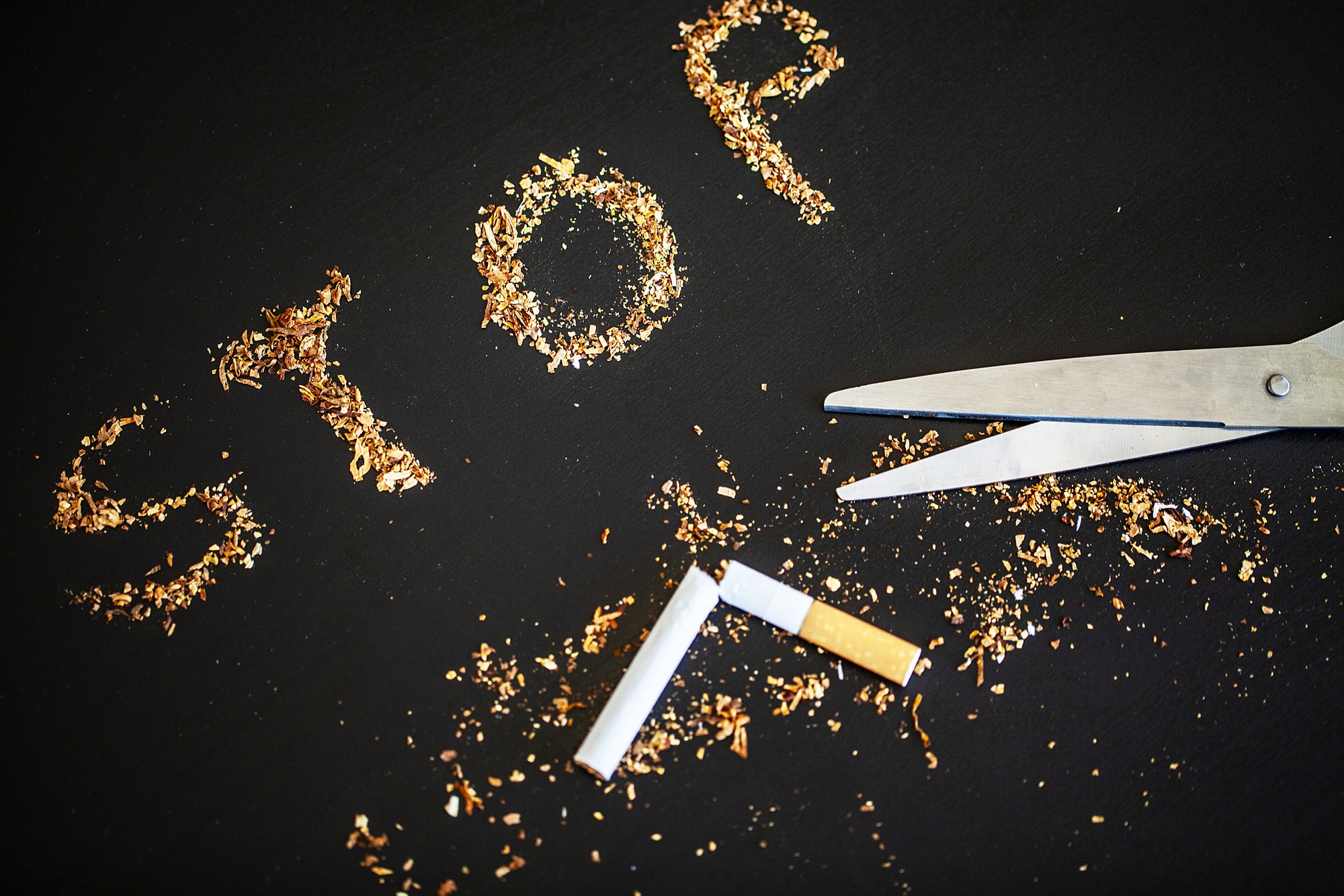Stop smoking concept on background with broken cigarettes. Heap of cigarettes. No smoking
