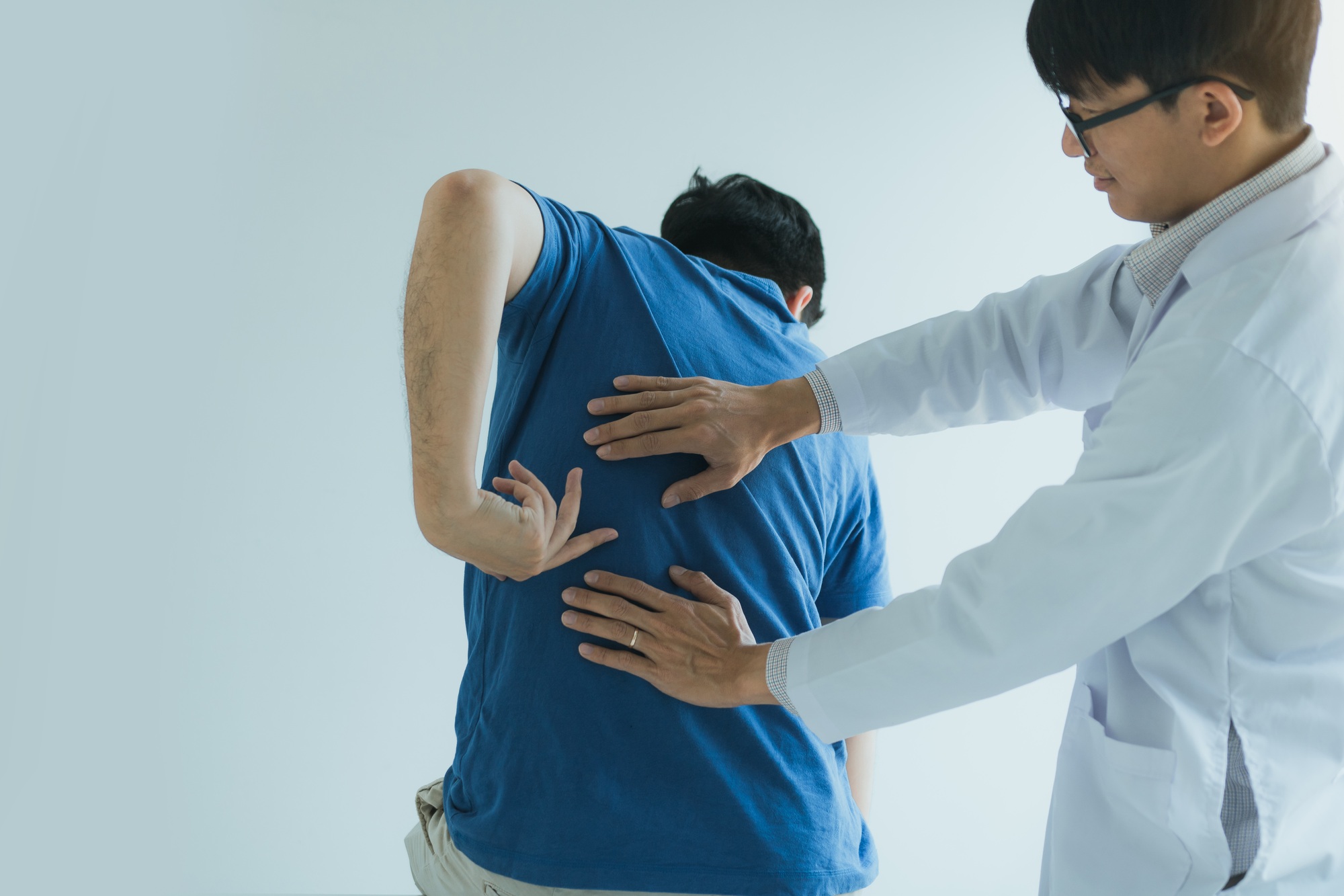 Patient is pointing to the point where the muscle pain is provided to the physical