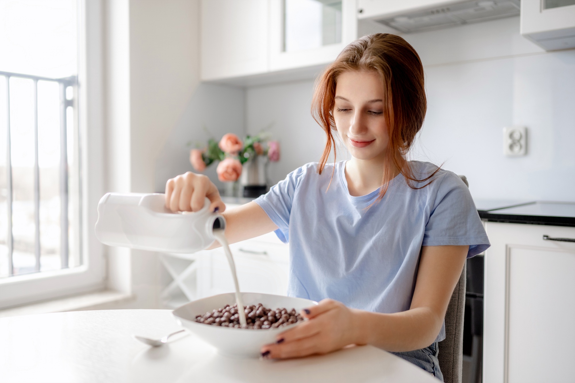 Cute Teenage Girl Pours Milk Into Bowl With Cereal