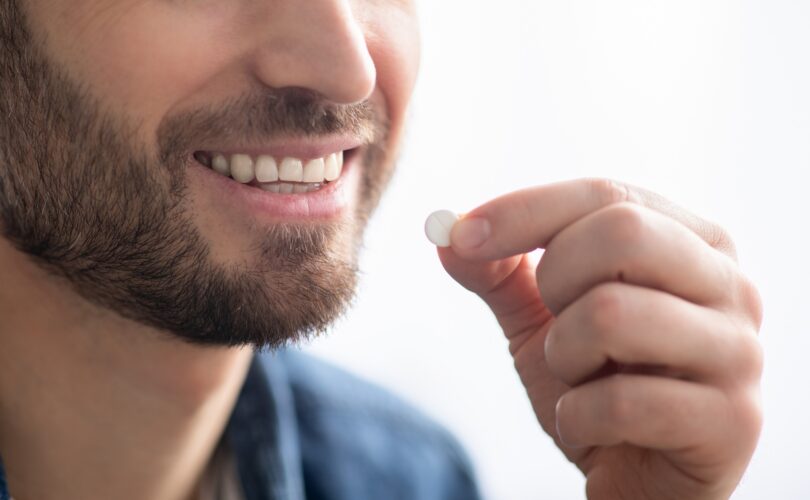 Unrecognizable smiling man taking medicine, copy space